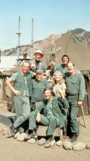 (v.l.) Hunnicut (Mike Farrell), Father Mulchy (William Christopher), Potter (Harry Morgan), Pierce (Alan Alda), Houlihan (Loretta Swit), Klinger (Jamie Farr) und Winchester (David Ogden Stiers)