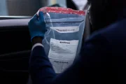 Der Detektiv hält die Tasche mit den Beweismitteln