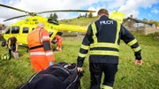 Rettungssanitäter und ein Pilot tragen einen verletzten Mann