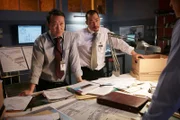 REENACTMENT - Lead Investigator (played by Oscar Hsu) finds the work order and looks up to consult with other investigators (played by background preformers). (Photo Credit: Cineflex/Ian Watson)