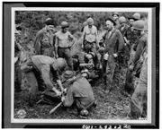 Guadalcanal - A casualty from the front line fighting is being transferred from the makeshift stretcher before being taken through jungle and down river to near hospital.