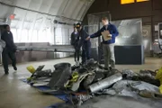 RE-CREATION:  Tom Haueter (played by Danny Deakin) tells other investigators (played by background performers) where to lay the pieces of the wreckage.   (photo credit:  Cineflix/Ian Watson)