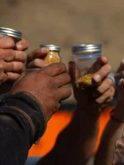 Close up - Everyone raises their jars of gold in tribute to & memory of Comrade/Husband Jesse Goins