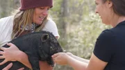 Misty holding a piglet with Kim feeding it at the Zabecs Homestead in Kinsale, Virginia.