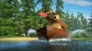 Der Bär pflügt mit dem Boot durch das Wasser.
