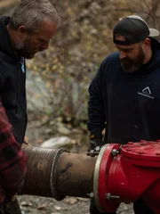 L-R: Buzz Legault, Ryan Kent fitting water intake hose with pipe adaptor to pump