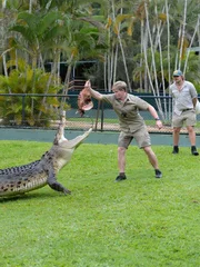 Robert Irwin holds an animal carcass for Bosco the crocodile to catch. Nick Kuyper, Terri Irwin and Harrison Varley watch on in background.