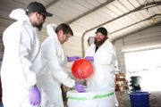 Tommy und Tory mit Laboranzügen beim Mischen von Sprengstoff