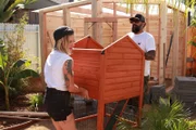 t Antonio Ballatore and build crew member, Christina Ray, carry small rabbit structure.
