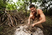 Andrew prepares wood for the fire.