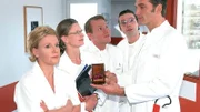 Dr. Schmidt (Walter Sittler, r.) präsentiert den Kollegen (v.l: Mariele Millowitsch, Kerstin Thielemann, Roland Jankowsky, Alexander Schottky) stolz seine neue Errungenschaft: Die goldene Tachonadel von Enzo Ferrari!