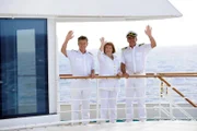 Dr. Sander (Nick Wilder), Beatrice (Heide Keller) und Kapitän Burger (Sascha Hehn) stehen winkend an Deck der MS Amadea.