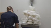 CBP-Beamter Bringle verwendet eine Waage, um Methamphetamin-Pakete zu wiegen, die im Fahrzeug eines Verdächtigen in Calexico, Kalifornien, entdeckt wurden (National Geographic for Disney).