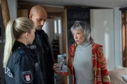 Monika Böckhold (Eva Kryll, r.) zeigt Lukas Petersen (Patrick Abozen, M.) und Jessy Jahnke (Farina Flebbe, l.) ein Foto ihrer verschwundenen englischen Bulldogge Morpheus. Die beiden Polizisten sollen sie suchen.