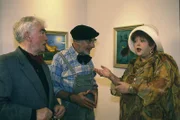 Der Kunstkritiker Herr Schmock (Peter Kock, l.) und die Förderin Frau Guggelheimer (Gundula Petrovska, r.) sind sich einig: Die Ausstellung von Peter Lustigs (Peter Lustig, M.) Hirsch-Bildern ist ein voller Erfolg geworden.