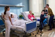 Jessika Wendel (Isabel Bongard, 2. von links) wird von Oberschwester Arzu (Arzu Bazman, links) auf ihr Zimmer gebracht. Dieses teilt sie sich mit Vollblutmutter Silke Bluhm (Floriane Daniel, 4. von rechts), die gerade Besuch ihres Mannes Thomas (Tobias Schulze) und ihrer Kinder hat. Arzu bittet die Rasselbande nun zu gehen, da Jessika jetzt Ruhe brauche.