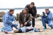 ARD HEITER BIS TÖDLICH - MORDEN IM NORDEN, III. Staffel der Krimiserie am Vorabend mit 8 neuen Folgen, Folge 33 "Der letzte Drink" am Dienstag (18.03.14) um 18.50 Uhr im Ersten. Die 19-jährige Coco (Komparsin) wird tot am Strand aufgefunden. Finn Kiesewetter (Sven Martinek, 2.v.l.), Lars Englen (Ingo Naujoks, 3.v.l.) und Dr. Strahl (Christoph Tomanek, l.) vermuten eine Methanol-Vergiftung. (Pressefotograf: Komparse)