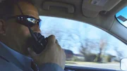 Ein Mann sitzt in einem Auto und spricht in ein Walkie-Talkie