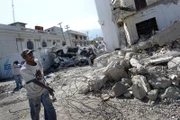 An earthquake survivor removes debris from a devastated road in Port-au-Prince, Haiti.