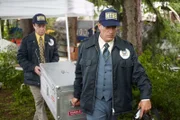 NTSB-Ermittler Al Diehl (gespielt von Thomas Mitchell, links) und ein weiterer NTSB-Ermittler tragen den FDR und das CVR von United Airlines Flug 173. Die Kisten werden zu den NTSB-Labors in Washington transportiert. Die Daten sollen erklären, warum das Verkehrsflugzeug mit 181 Passagieren und 8 Besatzungsmitgliedern an Bord 6 Meilen vor dem Portland International Airport in ein Waldgebiet stürzte. Die Besatzung hatte beim Anflug auf Portland ein Problem mit dem Fahrwerk gemeldet und beschlossen, den Flughafen zu umrunden, um das Problem zu beheben. Die Ermittler fanden heraus, dass der DC-8 während des Kreisens der Treibstoff ausging.