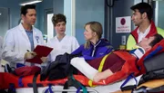 Auf der letzten Testfahrt vor ihrer Weltumrundung per Rad, hatten Nora (Johanna Klante, mi.) und Lutz Kleinschmidt (Thomas Bartling, liegend) einen Unfall. Der Notarzt (Roman Petermann, re.) übergibt die beiden in der Sachsenklinik an Dr. Philipp Brentano (Thomas Koch, li.) und Schwester Svenja Werth (Laura Louisa Garde, 2.v.li.).