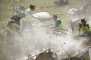 NACHSTELLUNG – Ein leitender Ermittler eines Flugzeugabsturzes (gespielt von Alex Karzis) und andere Ermittler (gespielt von Hintergrundkünstlern) sammeln Beweise im schwelenden Wrack des Spanair-Fluges 5022. (Bildnachweis: Cineflix/Ian Watson)