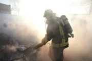 Feuerwehrleute löschten das Feuer des brennenden Flugzeugs nach dem Unfall.