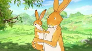Der große und der kleine braune Hase machen sich auf den Weg zum Blumenfeld.