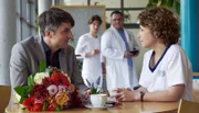 Kris Haas (Jascha Rust, hi.li.) macht Hans-Peter Brenner (Michael Trischan, hi.re.) auf Schwester Ulrike (Anita Vulesica, vo.re.)aufmerksam. Diese sitzt mit einem fremden Mann (Henning Vogt, vo.li.) in der Cafeteria. Das gefällt Hans-Peter ganz und gar nicht. Und dann hat der Mann auch noch Blumen dabei.