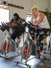 L-R: Ashely and Vannessa take a spin class at Fit Farm.