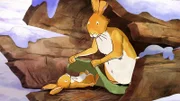Der große braune Hase deckt den kleinen braunen Hasen mit einer Moosdecke zu.