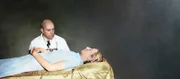 [2:04 PM] Timea Cirok Ein Wissenschaftler steht neben der Leiche einer verstorbenen Frau.