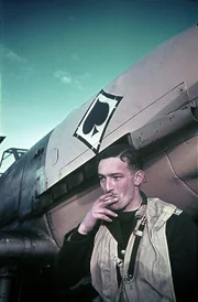 Ein Pilot der deutschen Luftwaffe raucht eine Zigarette vor seiner Messerschmitt Bf 109.