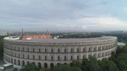 Das inzwischen halb zugewachsene Zeppelinfeld in Nürnberg, welches von hohen Mauen umgeben ist, umfasst die Fläche von zwölf Fußballfeldern.