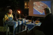 Peter (Peter Lustig, l.) zeigt seinem Nachbarn Paschulke (Helmut Krauss, r.) die "Staub-Symphonie" - mit Musik und phantastischem Staub unter dem Mikroskop, der auf die Leinwand projiziert wird.