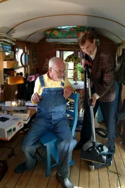 Peter (Peter Lustig, l.) hat überhaupt keinen Bedarf an einem Staubsauger, den ihm der Vertreter (Gode Benedix, r.) mit allen Mitteln anpreist.