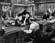 Im Saloon erkundigen sich Stan (Stan Laurel – links an der Theke) und Ollie (Oliver Hardy – rechts an der Theke) beim Besitzer (James Finlayson – mit dem Rücken zu Kamera) nach Mary Roberts, der sie ihre Erbschaft überbringen sollen. Obwohl es ein Geheimnis sein soll, worum es sich dabei handelt, plaudert es Stan sofort aus.