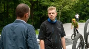 Jerry Paulsen (Peter Marton, l.) stellt Franz Grünberger (Johannes Berzel, r.) im Bikepark zur Rede. Franz streitet die Vorwürfe ab (mit Komparsen, h.).