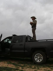 Shot of open field and Texas Game Warden and his vehicle.