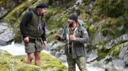 Joseph Teti discusses the plain with Cody Lundin as they stand by a rushing stream of water.