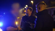 Die Polizeibeamten sprechen mit dem Fahrer