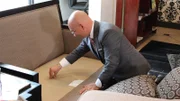 Anthony inspects a couch in the lobby of the Curve Hotel, as seen on Travel Channel's Hotel Impossible.