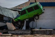 A damaged car on a house after being hit by the tsunami on October 5, 2018 in Palu, Central Sulawesi, Indonesia. The death toll from last weeks earthquake and tsunami has risen to at least 1,558 but widely expected to rise as officials said on Friday the number of victims of the liquefaction could be up to a thousand. Power had returned to parts of the city and fuel shipments have begun to flow back but some affected towns remain inaccessible with the infrastructure badly damaged. A tsunami triggered by a magnitude 7.5 earthquake slammed into Indonesia's coastline on the island of Sulawesi which destroyed or damaged over 70,000 homes as tensions remain high with desperate survivors trying to secure basics like clean water and fuel for generators.