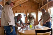 Eric Drummond, Chad Ollinger, Charlie Snider and Duane Ollinger look at a jarred green substance on the table.