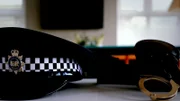 Polizeimütze und Handschellen