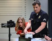 Officer John Nolan (Nathan Fillion) steht vor einer kniffligen Aufgabe: Er soll die Fingerabdrücke einer jungen Frau (Marnee Carpenter) nehmen, die sich hartnäckig dagegen wehrt.