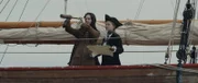 REENACTMENT - Anne Bonny schaut durch ein Fernrohr mit Mary Read, die als männlicher Pirat verkleidet ist.