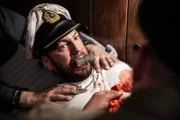 In einer dramatischen Nachstellung lässt Kapitänleutnant Friedrich Markworth (L, Leszek Brugmann) seine Wunden nach einem Flugzeugangriff versorgen. (Pacific Fleet II Productions Inc./Sean F. White)