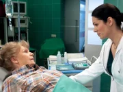 Dr. Elena Eichhorn (Cheryl Shepard, rechts) erklärt Ilse Friedel (Ingeborg Krabbe), dass sie den gebrochenen Oberschenkel operieren müssen. Ilse Friedel macht sich Sorgen um ihre Enkelin, um die sie sich dann nicht kümmern kann, doch schließlich stimmt sie der OP zu.