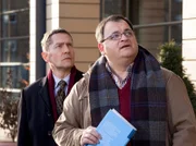 Hans-Peter Brenner (Michael Trischan, rechts) hat eine urologische Fachfrage an Dr. Rolf Kaminski (Udo Schenk) und fängt diesen vor der Klinik ab. Doch Kaminski entdeckt auf dem Klinikdach Emil Lerchfeld, der ziemlich nah am Rand steht.